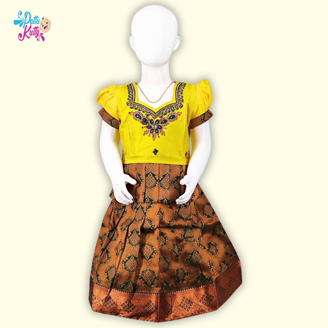 This Pattu Pavadai comes in combination with Yellow Stone work top with Frill Design and Green and Golden toned printed skirt.