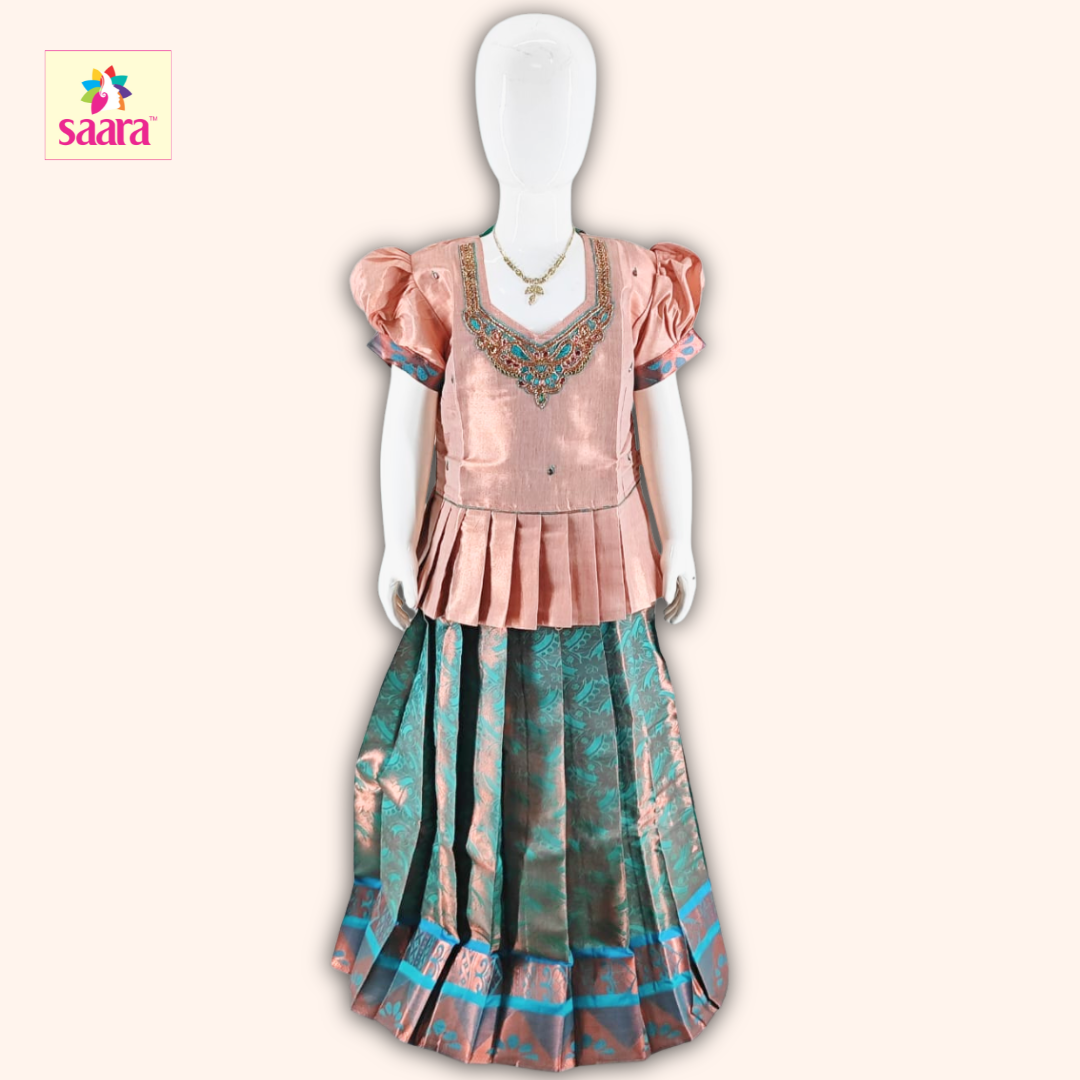 This Pattu Pavadai features a Copper blouse with Aari work, puffed sleeves and a matching Green skirt made of s jacquard fabric.