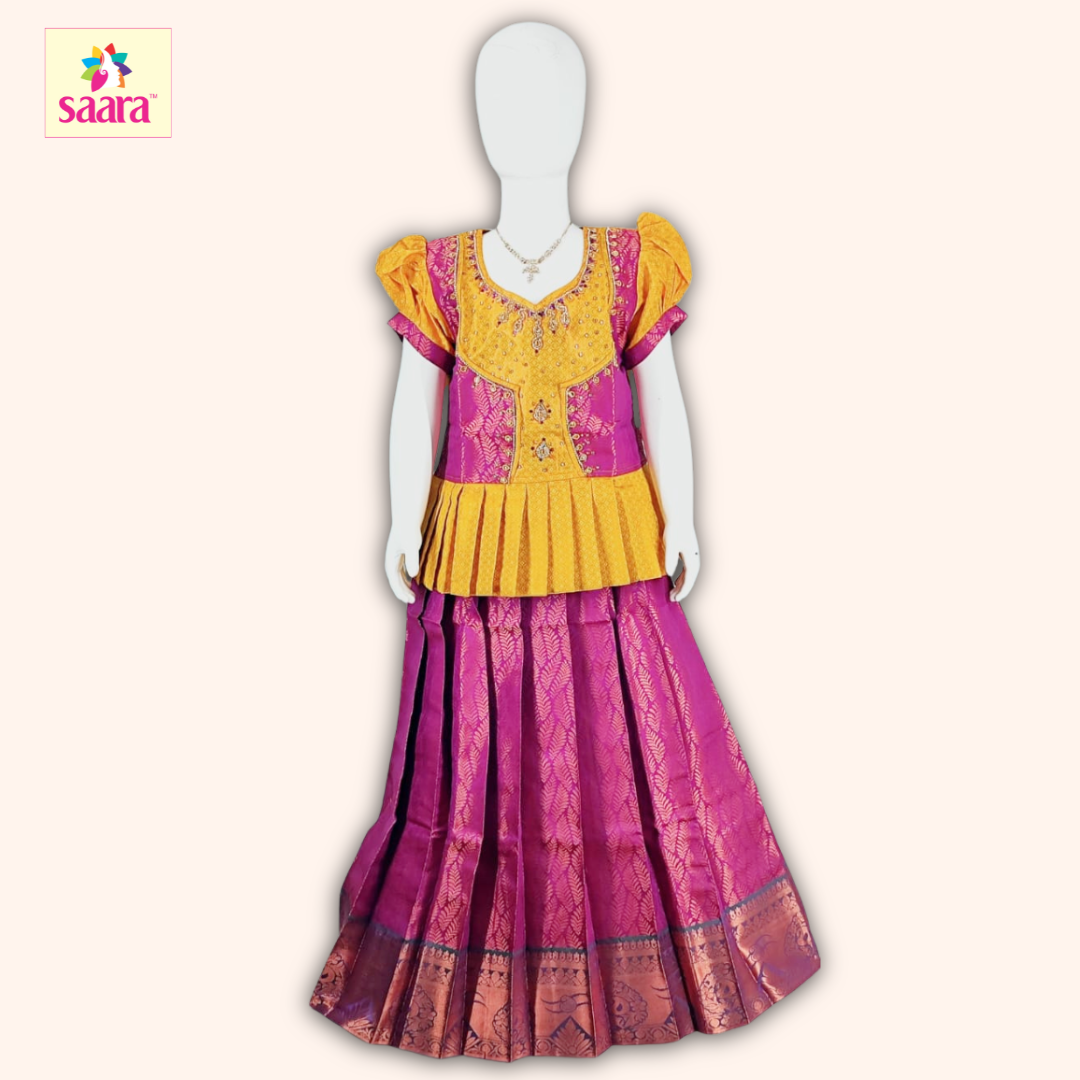 This Pattu Pavadai features a Yellow blouse with attached overcoat design with stonework, puffed sleeves and a matching Pink skirt made of jacquard fabric.