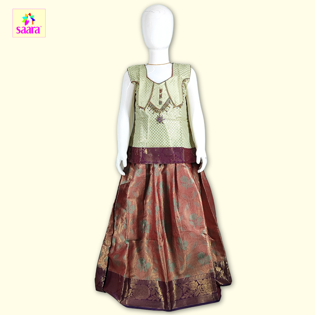 This PattuPavadai features Sleeveless Green top with piping and stone work paired with Brown skirtwith floral motifs.