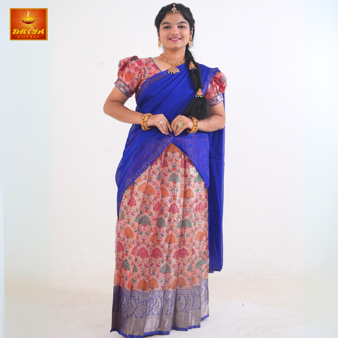 This Half saree features blue shawl with embellishment at the hem and peach floral printed Skirt ,Zari border, and matching Puff sleeve blouse.
