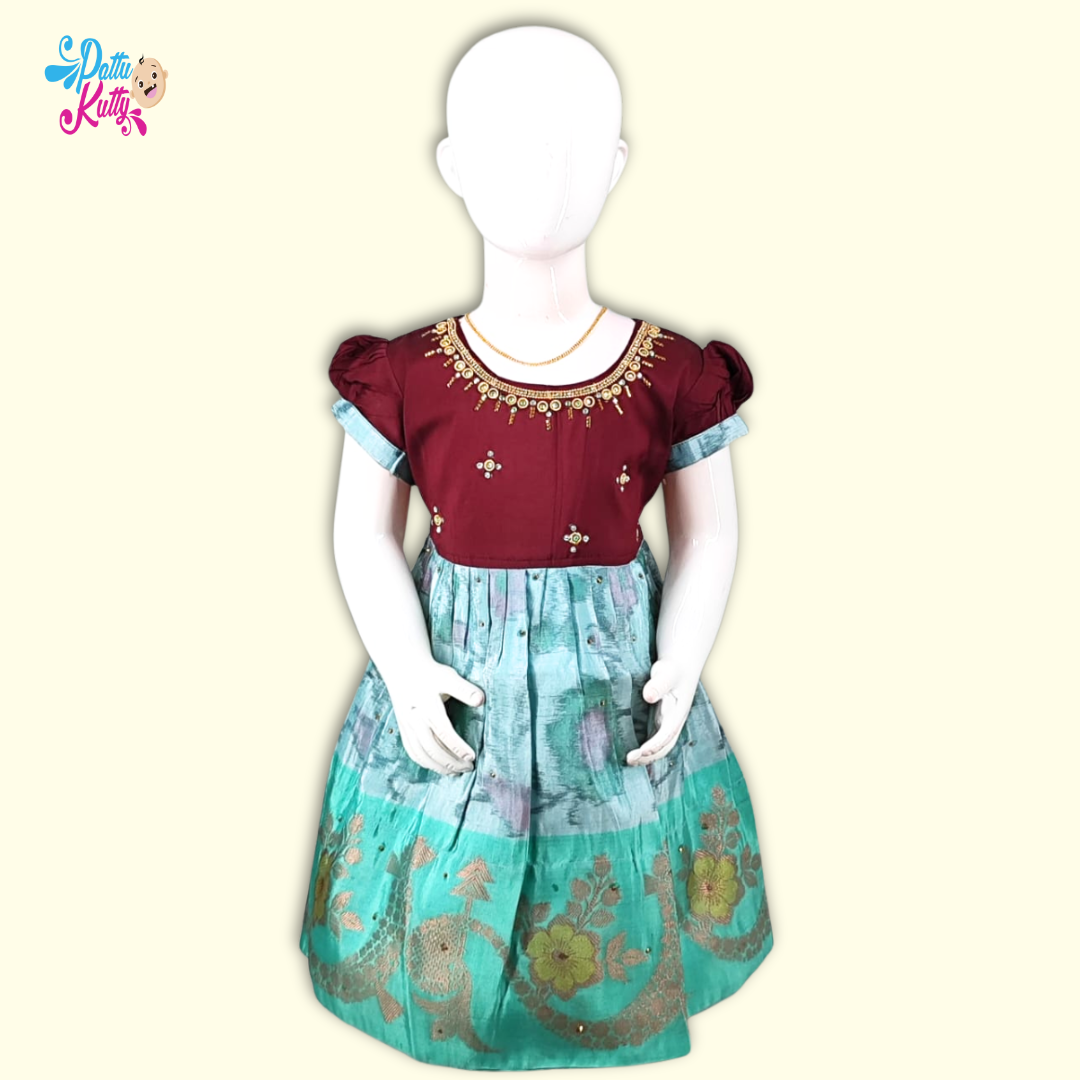 This Pattu Frock comes in combination with Maroon Stone work top with Green floral printed skirt.